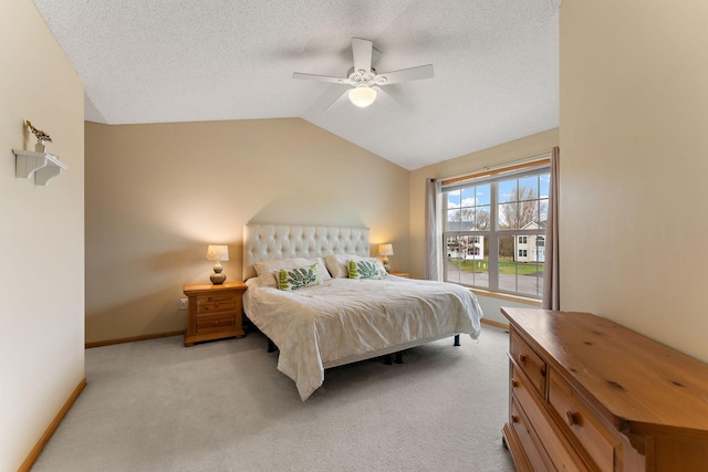 bedroom featuring light colored carpet, a textured ceiling, baseboards, and lofted ceiling