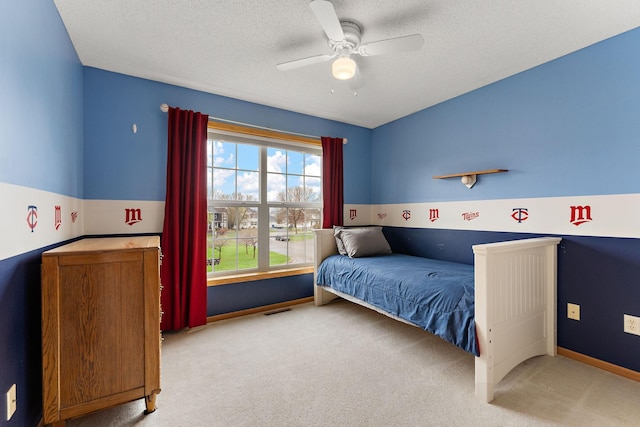 bedroom with ceiling fan, carpet floors, a textured ceiling, baseboards, and visible vents