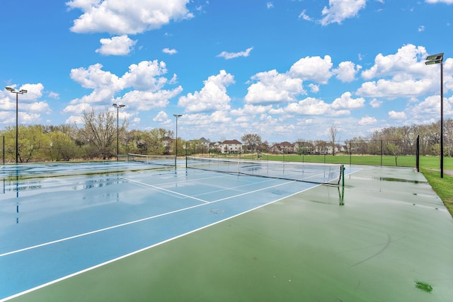 view of tennis court featuring fence