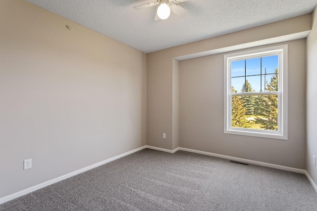 carpeted spare room with ceiling fan, baseboards, and a textured ceiling