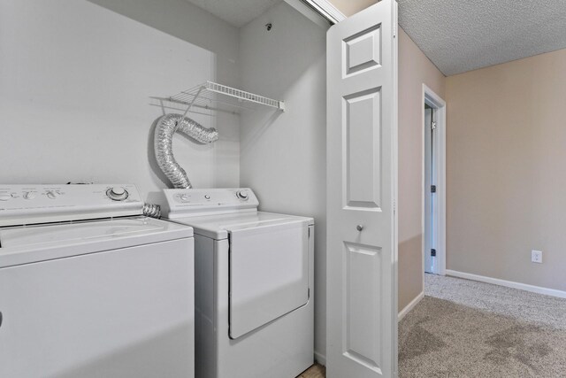 laundry room with independent washer and dryer, light colored carpet, and baseboards