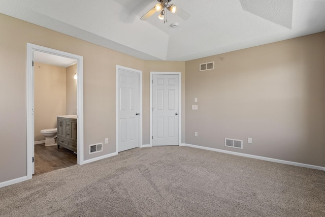unfurnished bedroom with carpet floors, connected bathroom, baseboards, and ceiling fan
