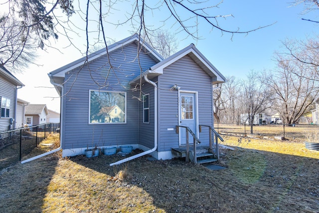 back of property with entry steps and fence