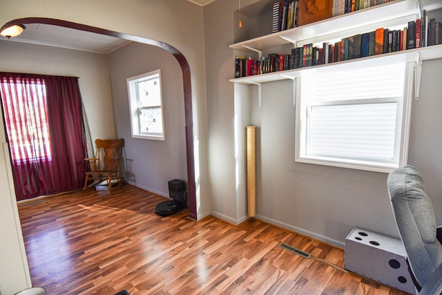 interior space featuring visible vents, arched walkways, and wood finished floors
