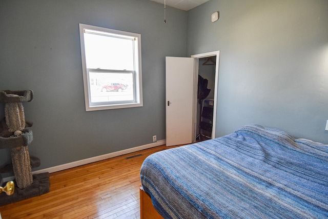 bedroom with visible vents, baseboards, and hardwood / wood-style flooring
