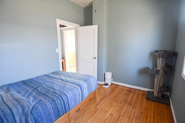 bedroom featuring baseboards and hardwood / wood-style flooring