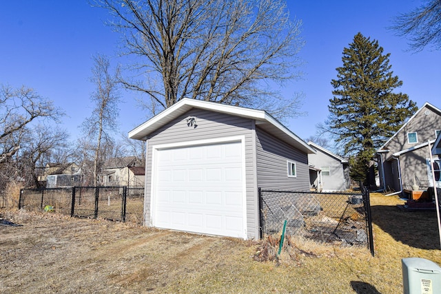 garage with fence and dirt driveway