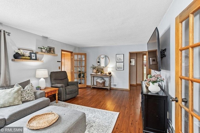 518 State St E, Cannon Falls, MN 55009 - living room featuring french doors, a textured ceiling, wood finished floors, and baseboards