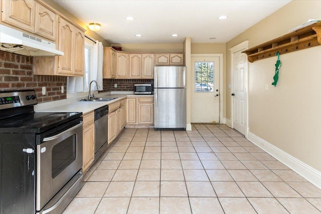 kitchen featuring light brown cabinets, a sink, under cabinet range hood, stainless steel appliances, and light tile patterned flooring
