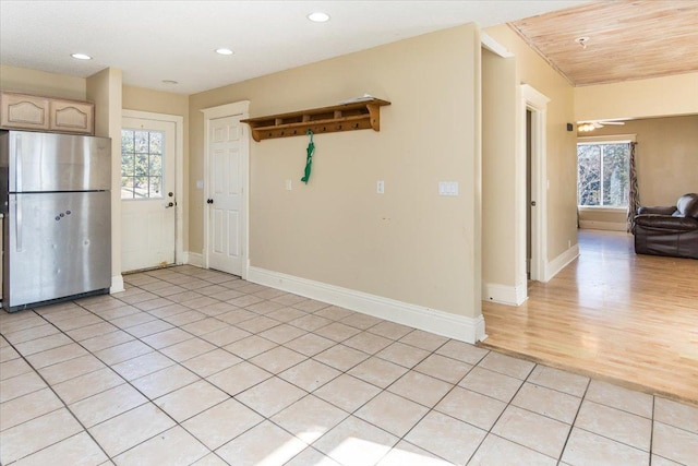 kitchen with baseboards, recessed lighting, open floor plan, light tile patterned floors, and freestanding refrigerator