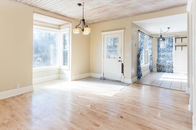 unfurnished dining area featuring wood ceiling, wood finished floors, a notable chandelier, and baseboards