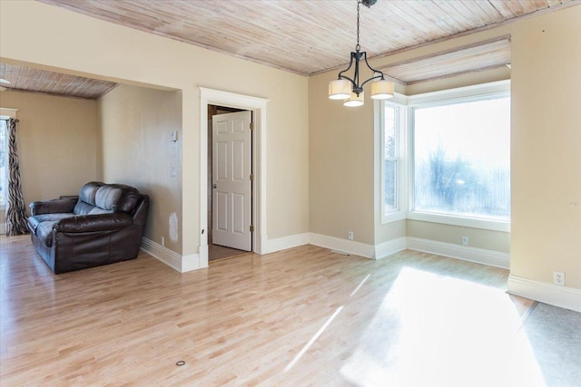empty room featuring light wood-style floors, a notable chandelier, wood ceiling, and baseboards