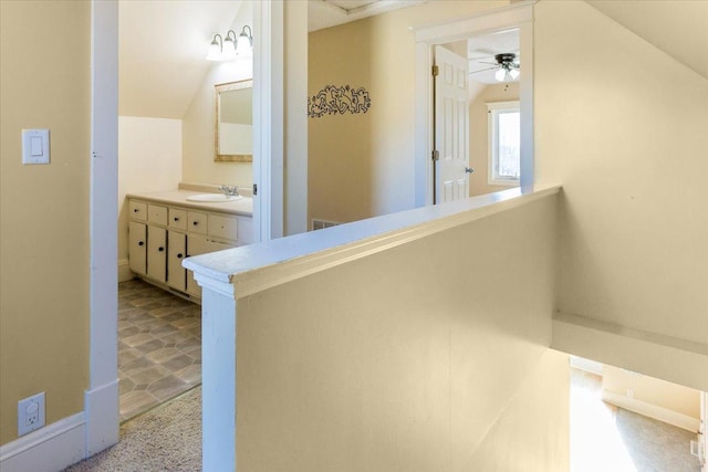 hallway featuring a sink and lofted ceiling