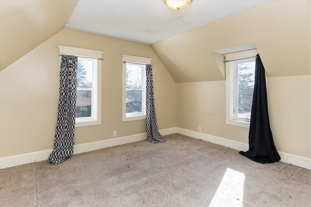 additional living space with baseboards, carpet, and lofted ceiling