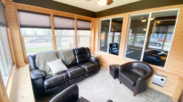 living room with a ceiling fan and wooden walls