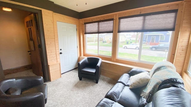 carpeted living area with wooden walls