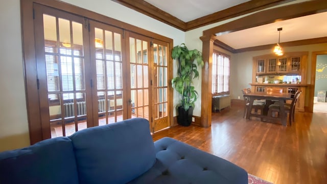 living area with crown molding, french doors, baseboards, radiator heating unit, and wood finished floors