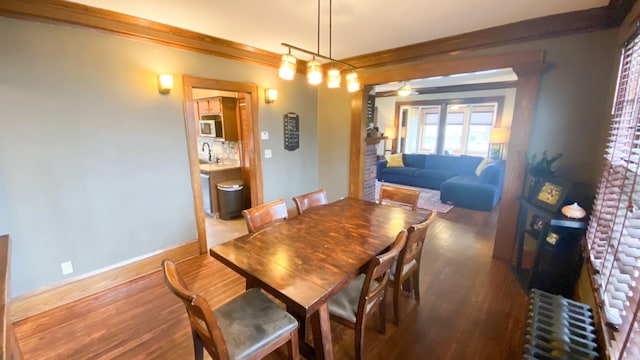 dining area featuring radiator, wood finished floors, and baseboards