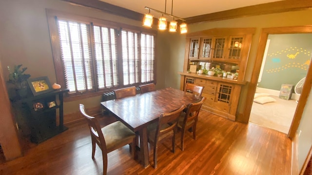 dining area featuring track lighting, wood finished floors, and baseboards