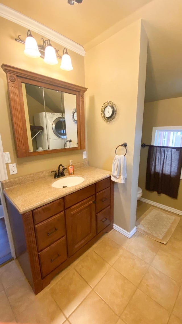 bathroom featuring crown molding, washer / dryer, toilet, vanity, and tile patterned flooring