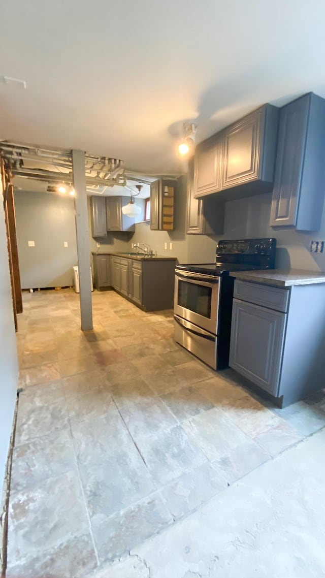 kitchen with gray cabinetry, a sink, and stainless steel range with electric cooktop