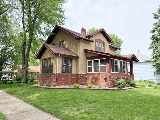 1201 6th Ave, Worthington, MN 56187 - view of front of house featuring a chimney, stucco siding, a front yard, and brick siding