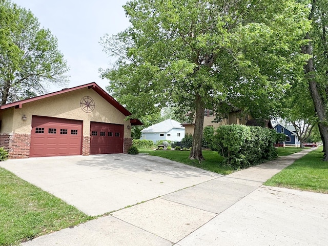 1201 6th Ave, Worthington, MN 56187 - view of side of property with stucco siding, brick siding, a lawn, and driveway