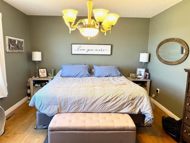 32661 County Road 16, Ross, MN 56751 - bedroom featuring a chandelier, wood finished floors, and baseboards