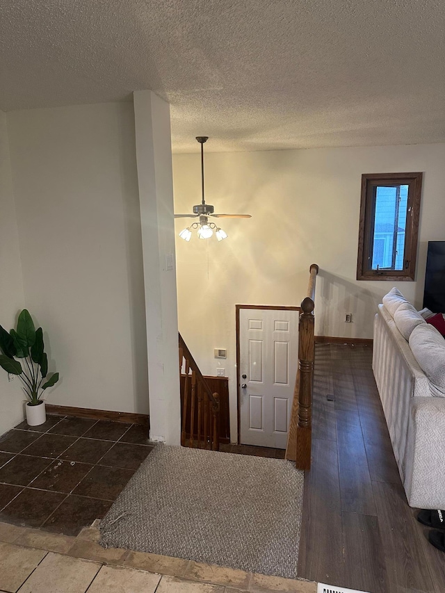 entryway featuring ceiling fan, a textured ceiling, and baseboards