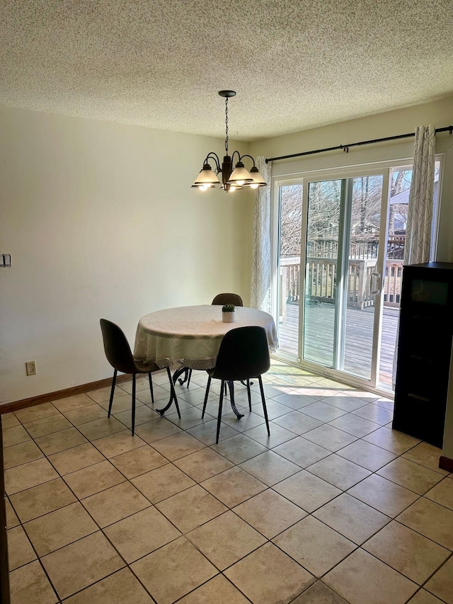 dining area featuring a textured ceiling, a chandelier, and light tile patterned floors