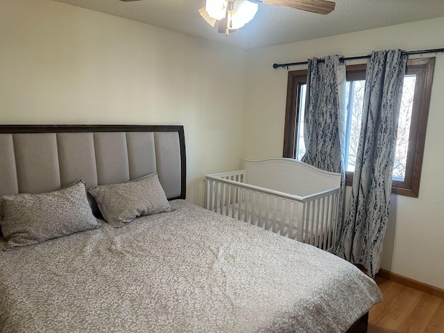 bedroom featuring wood finished floors, baseboards, and ceiling fan