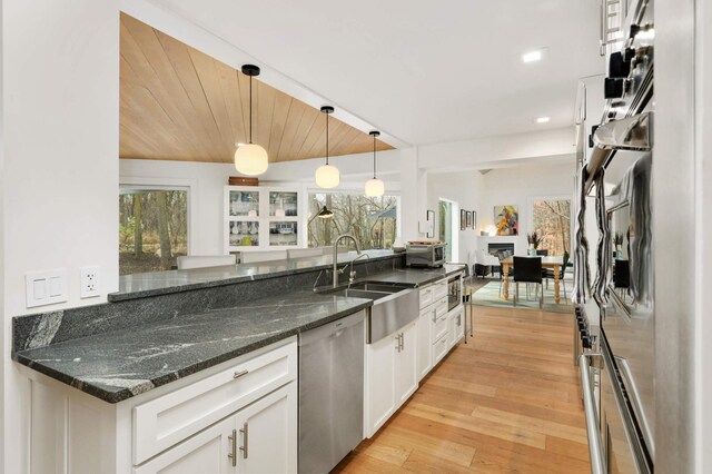 285 Leaf St, Orono, MN 55356 - kitchen with stainless steel dishwasher, a sink, white cabinetry, light wood-style floors, and decorative light fixtures