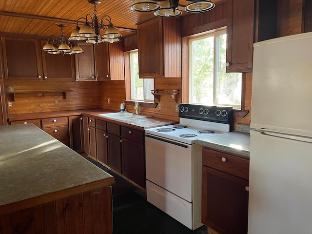 40884 Nature Ave, Fleming Twp, MN 56431 - kitchen featuring white appliances, a chandelier, wooden ceiling, a sink, and wooden walls