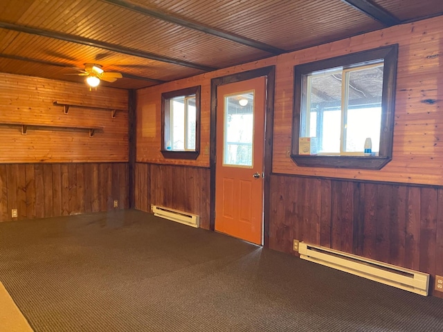 40884 Nature Ave, Fleming Twp, MN 56431 - spare room with a baseboard heating unit, wood walls, carpet floors, and a ceiling fan