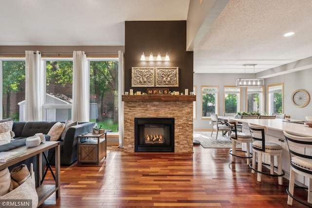 4022 Yosemite Ave S, Saint Louis Park, MN 55416 - living room with wood-type flooring, a wealth of natural light, a stone fireplace, and a textured ceiling