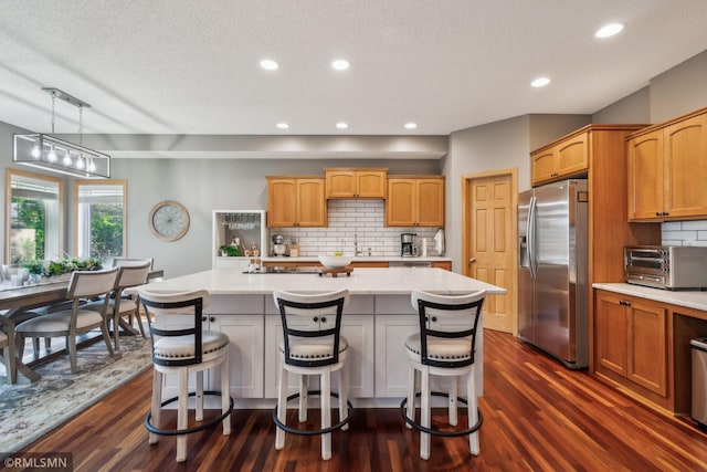4022 Yosemite Ave S, Saint Louis Park, MN 55416 - kitchen with a center island, decorative backsplash, stainless steel fridge with ice dispenser, a toaster, and dark wood finished floors