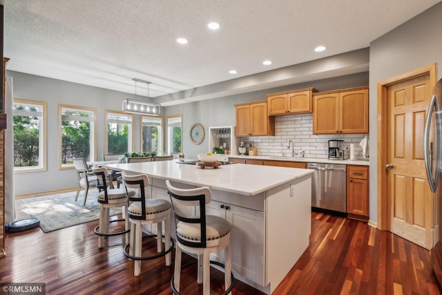 4022 Yosemite Ave S, Saint Louis Park, MN 55416 - kitchen with dark wood-style floors, a sink, a center island, a textured ceiling, and dishwasher