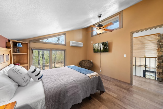3626 Bay Dr, Danbury, WI 54830 - bedroom with lofted ceiling, an AC wall unit, wood finished floors, a textured ceiling, and access to exterior