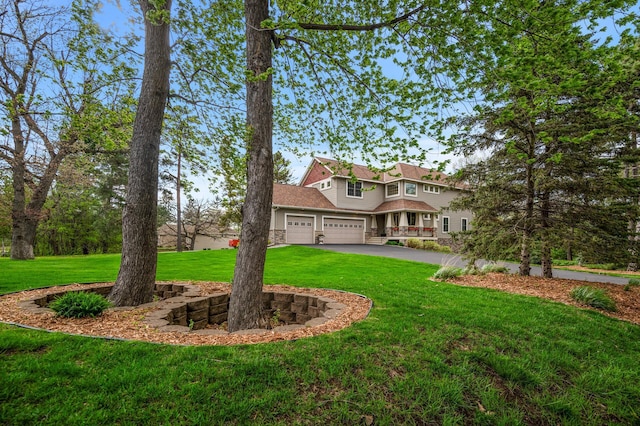 exterior space with driveway, a front lawn, and a garage