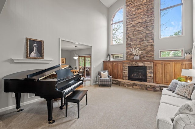 carpeted living area with high vaulted ceiling, a fireplace, and baseboards