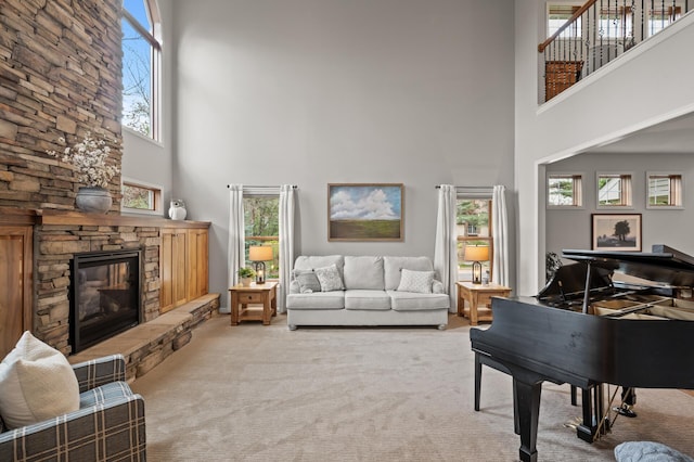 carpeted living room with a fireplace and a towering ceiling