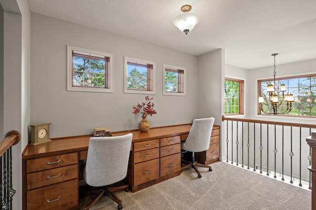 office space with a chandelier and light colored carpet