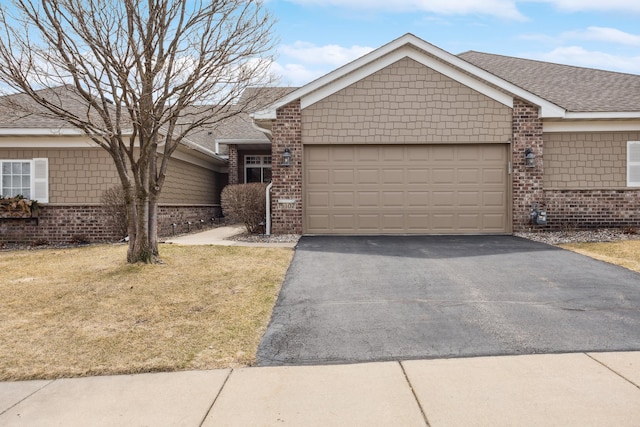 single story home with brick siding, driveway, a garage, a front lawn, and roof with shingles