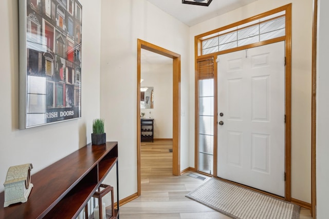 foyer featuring light wood-style flooring and baseboards