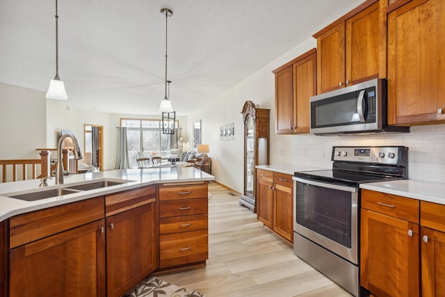 kitchen with stainless steel appliances, a sink, light countertops, and backsplash