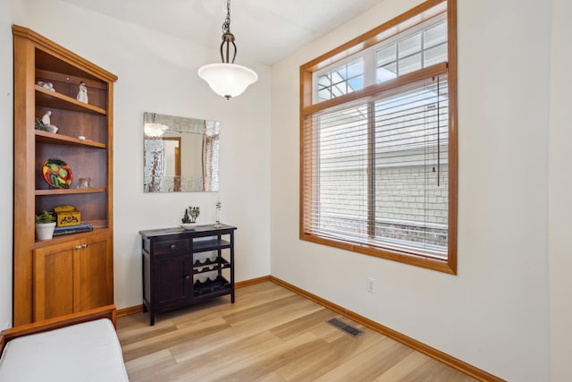 dining space featuring light wood finished floors, healthy amount of natural light, and baseboards