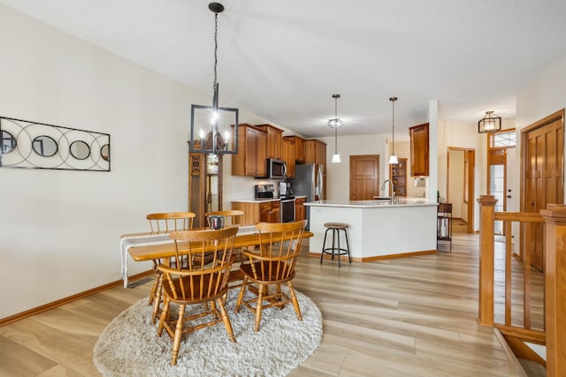 dining area featuring baseboards and light wood-style flooring