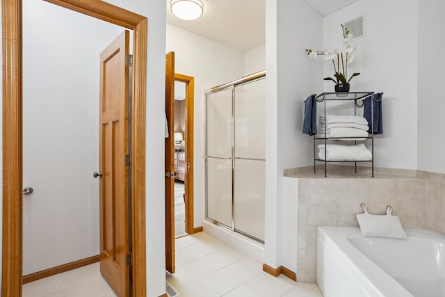 full bathroom featuring a stall shower, a garden tub, baseboards, and tile patterned floors