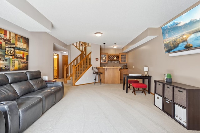 living room with light colored carpet, bar with sink, stairway, and baseboards