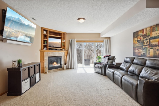 carpeted living room with a textured ceiling, a fireplace, and built in features